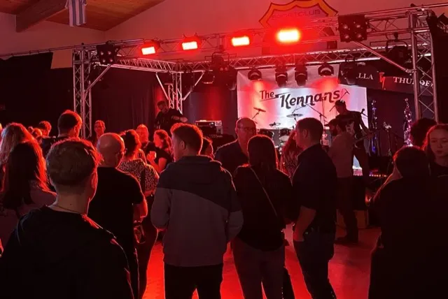 Band-Auftritt mit rotem Bühnenlicht vor Publikum